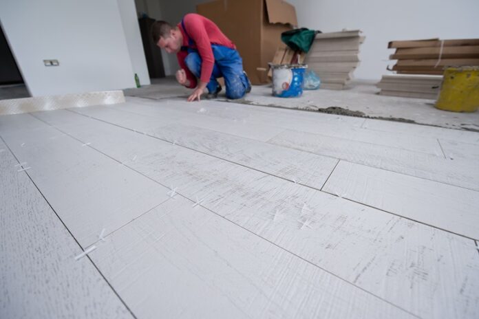 worker installing the ceramic wood effect tiles on the floor